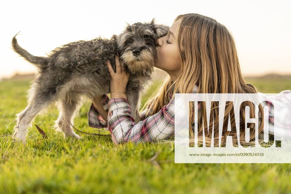 Girl lying on a meadow kissing her dog model released Symbolfoto property released ERRF00687