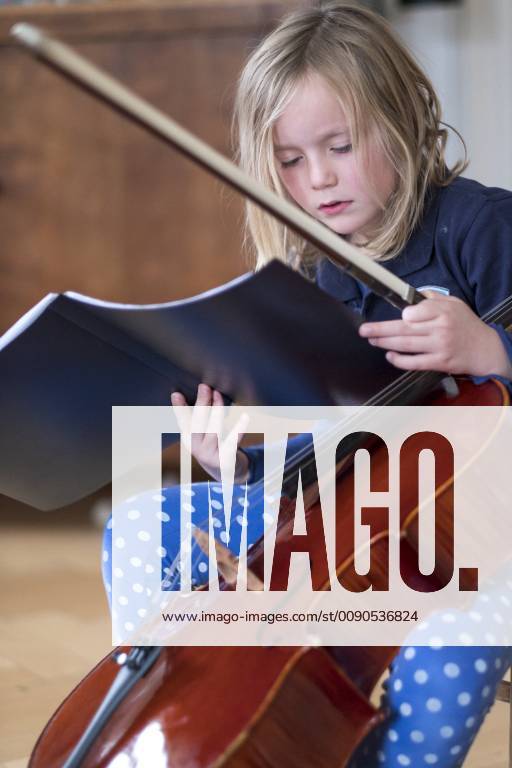 IMAGO Creative: Bildung, Musikerziehung Portrait of blond girl with cello and bow looking at musical notes model released Symbolfoto HAMF00561