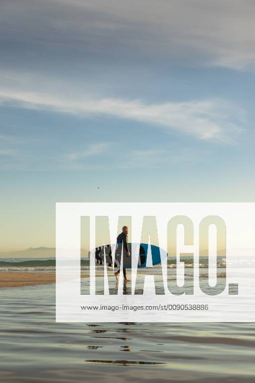 Spain, Andalusia, Tarifa, man walking with stand up paddle board on the beach model released Symbolfoto KBF00359