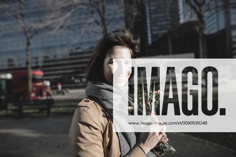 Portrait of smiling woman with bunch of flowers in the city model released Symbolfoto KMKF00678