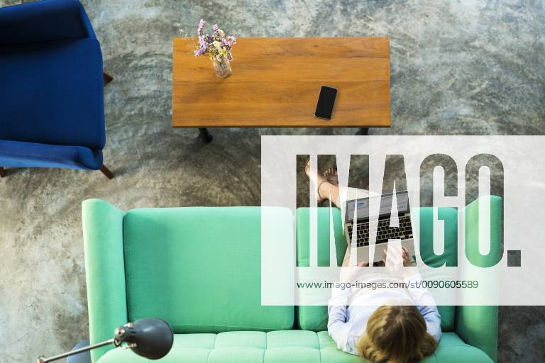 Top view of businesswoman working on laptop on turquoise couch in coworking space model released Symbolfoto property released SBOF01544
