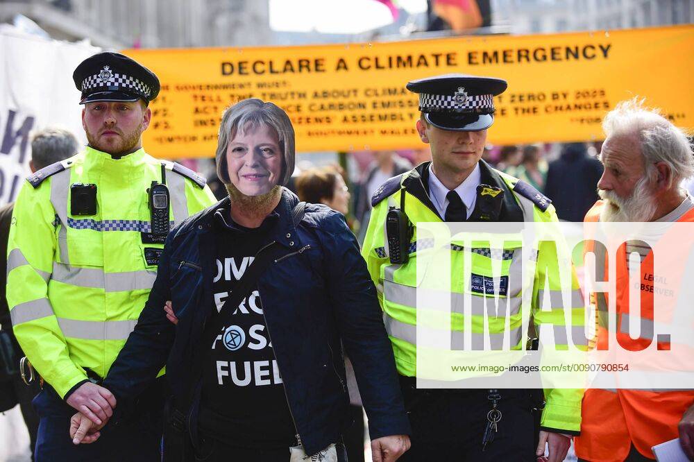 London, UK - LONDON, UK. Police officers arrest a protester, who is wearing a Thresa May face mask, at Oxford Circus during London: International Rebellion , on day three of a protest organised by Extinction Rebellion, demanding that governments take action against climate change. Marble Arch, Oxford Circus, Piccadilly Circus, Waterloo Bridge and Parliament Square have been blocked by activists in the last three days. Police have issued a section 14 order requiring protesters to convene at Marble Arch only so that the protest can continue. London UK - ZUMAl94_ 20190417_zaf_l94_039