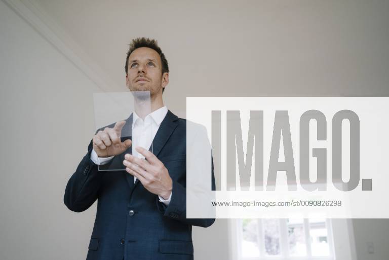 Businessman using glass touch screen in a new home model released Symbolfoto property released KNSF05473