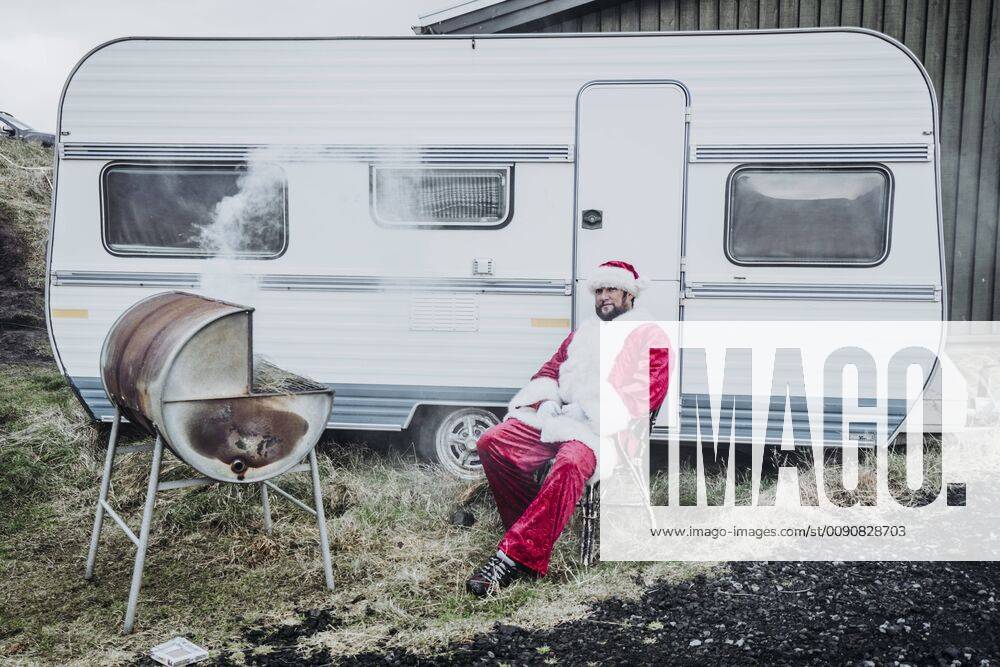Iceland, Santa Claus sitting in front of caravan barbecueing model released Symbolfoto OCMF00182