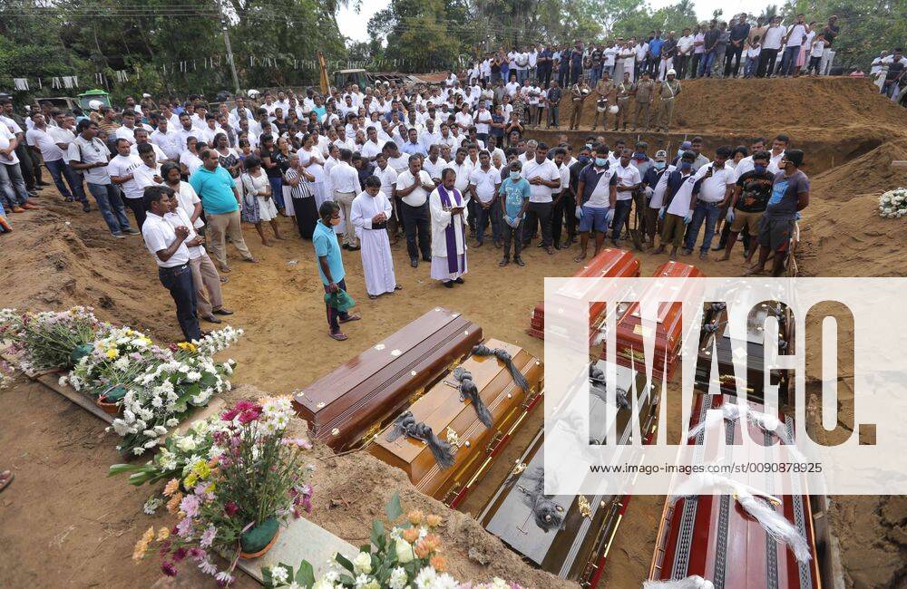 Colombo, Sri Lanka - Coffins are laid for burial as a Sri Lankan catholic priest surrounded by devotees and family members of the victims carry out religious rituals during a mass burial for Easter Sunday Church bomb blast victims in Negombo, Sri Lanka, Wednesday, 04- 24-2019. Colombo Sri Lanka - ZUMAn230 20190424_zaa_n230_083