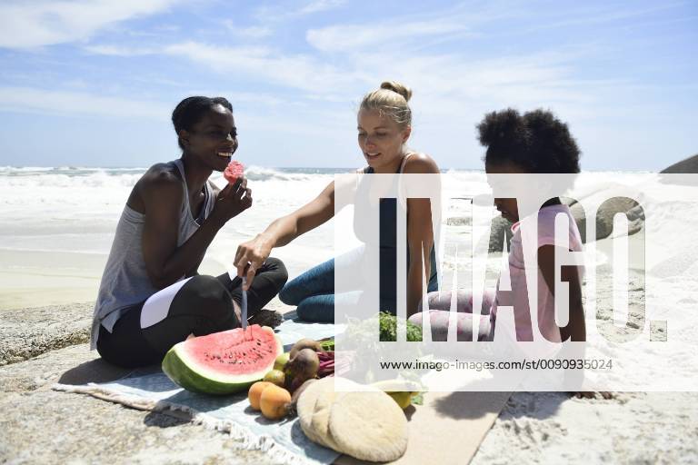 Mother with daughter and friend having a picnic on the beach model released Symbolfoto ECPF00421