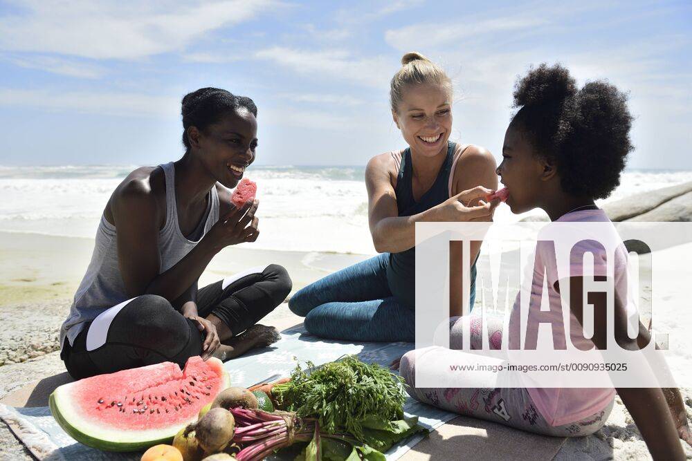 Mother with daughter and friend having a picnic on the beach model released Symbolfoto ECPF00422