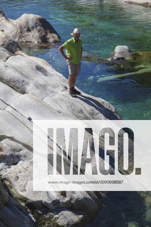 Switzerland, Ticino, Verzasca Valley, man standing on rock at clear turquoise waters of Verzasca river model released Symbolfoto GWF05952
