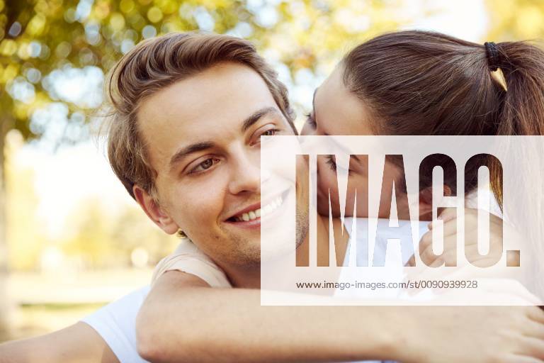 Happy young couple in love kissing at a park model released Symbolfoto JHAF00065