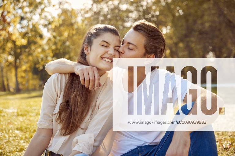 Happy young couple kissing at a park model released Symbolfoto JHAF00070