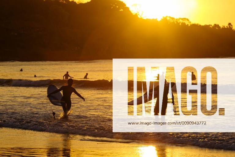Surfers at sunset on the beach, Bali, Indonesia model released Symbolfoto KNTF02665