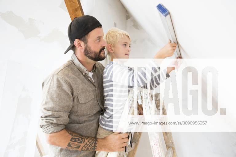 Father and son working on loft conversion using water level model released Symbolfoto property released MFRF01171