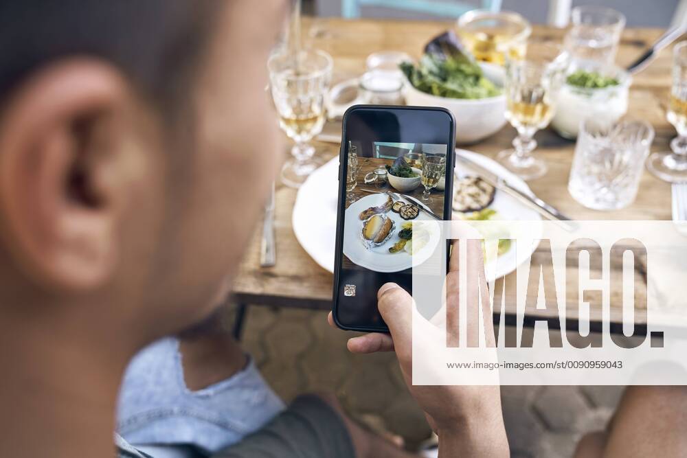 Man taking a picture of the food at a barbecue party model released Symbolfoto property released PDF01845