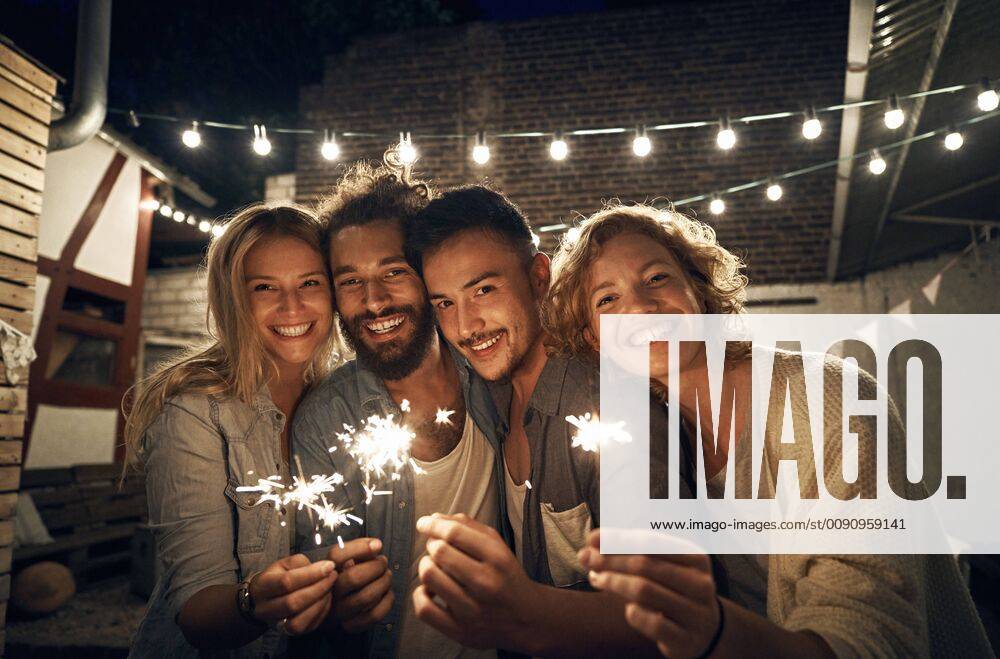 Freinds having a backyard party, burning sparklers model released Symbolfoto property released PDF01885