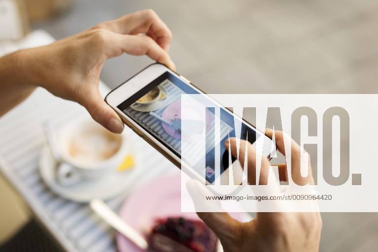 Female hands taking a picture of piece of cake with smartphone model released Symbolfoto VABF02229