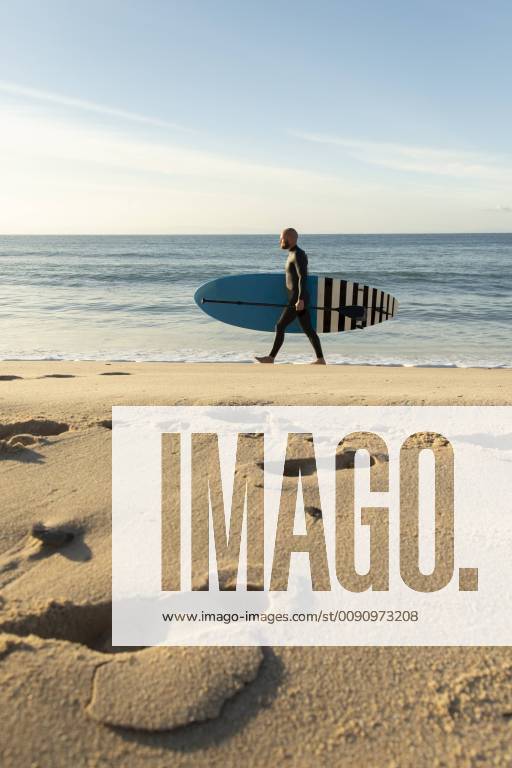 Spain, Andalusia, Tarifa, man walking with stand up paddle board on the beach model released Symbolfoto KBF00368
