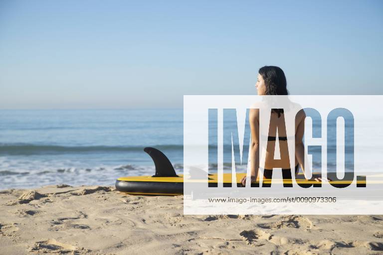 Spain, Andalusia, Tarifa, woman sitting on stand up paddle board on the beach model released Symbolfoto KBF00393