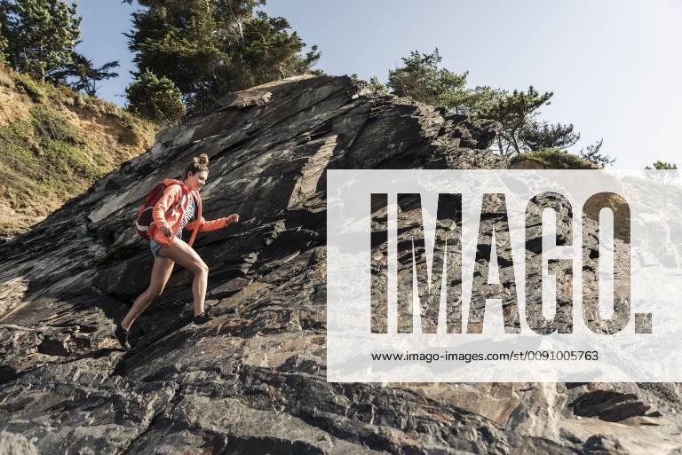 Young woman hiking on a rocky beach model released Symbolfoto UUF16448