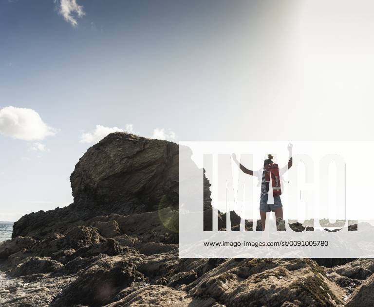 Young woman runnning and jumping on a rocky beach model released Symbolfoto UUF16457