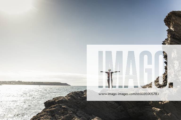 Young woman hiking on a rocky beach, looking at view model released Symbolfoto UUF16462