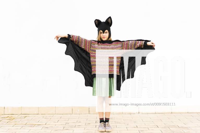 Portrait of girl in bat costume spreading wings in front of white wall model released Symbolfoto property released ERRF00988