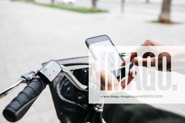 Close-up of man with e-bikeusing smartphone navigation system model released Symbolfoto property released JRFF02959