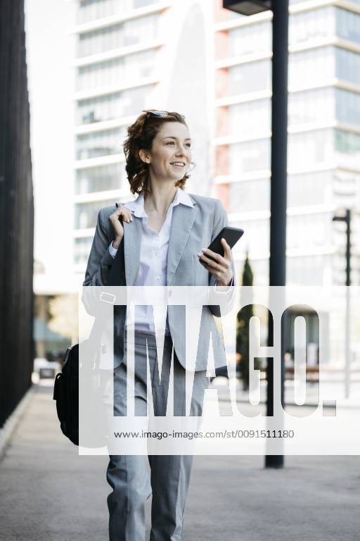 Businesswoman with smartphone, commuting in the city model released Symbolfoto JRFF03055