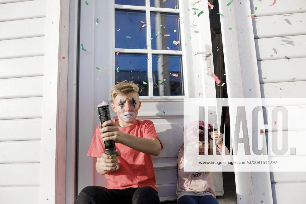 Brother and little sister made up for carnival sitting in front of entry door model released Symbolfoto property released KMKF00787