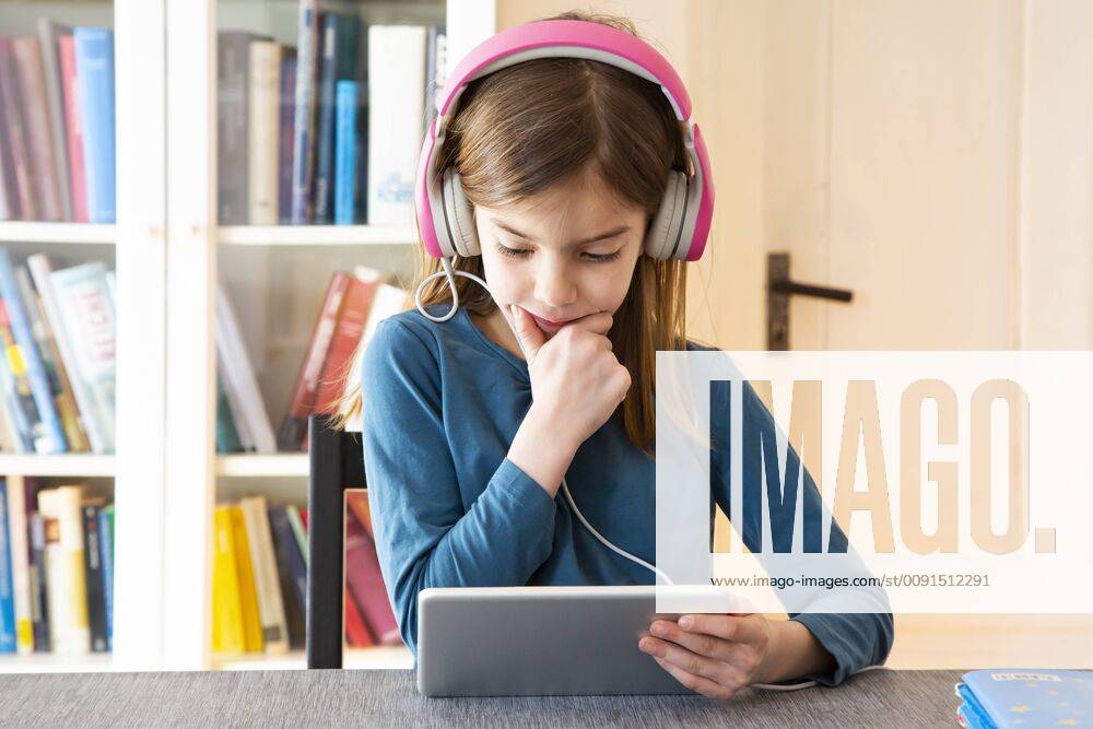 Little girl doing homework with headphones and digital tablet model released Symbolfoto property released LVF07945