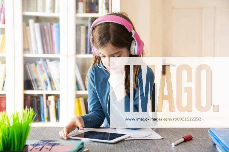Little girl doing homework with headphones and digital tablet model released Symbolfoto property released LVF07946