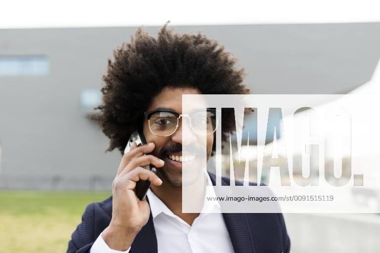 Spain, Barcelona, portrait of smiling businessman on cell phone in the city model released Symbolfoto VABF02256