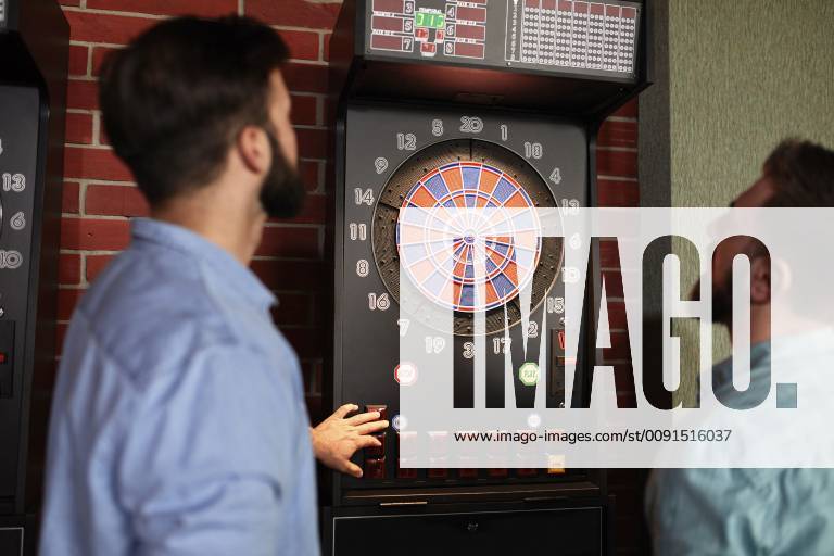 Two men playing darts setting electronic dartboard model released Symbolfoto property released ZEDF02017