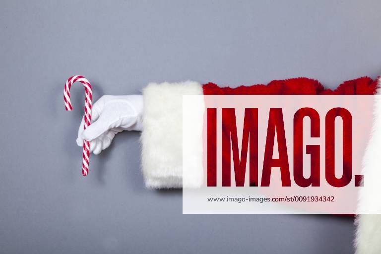 Santa Claus holds candy cane in hand