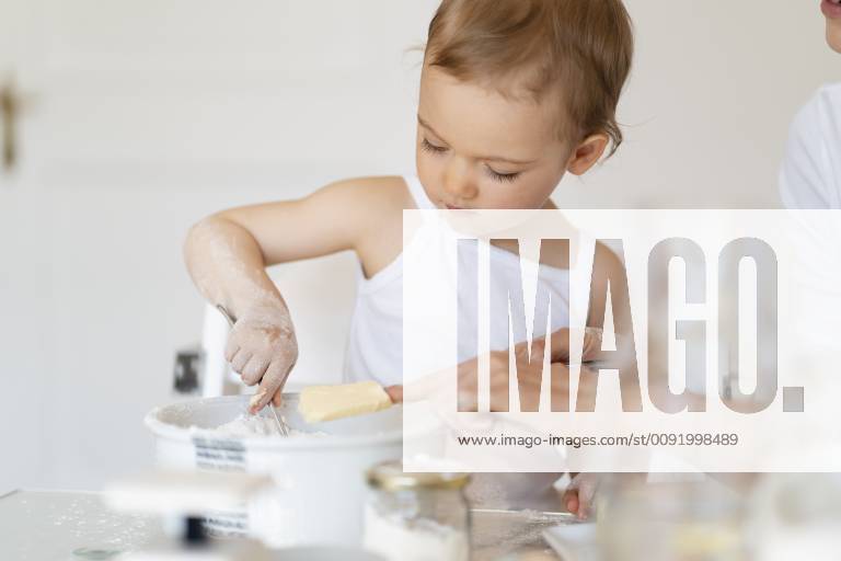 Mother and little daughter making a cake together in kitchen at home model released Symbolfoto property released DIGF06767