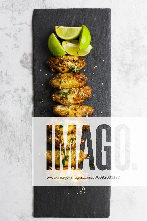 Spicy chicken wings with lime on slate GIOF06383