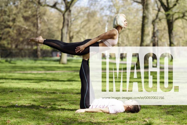 Young couple doing yoga acrobatics in an urban park model released Symbolfoto JSMF01075
