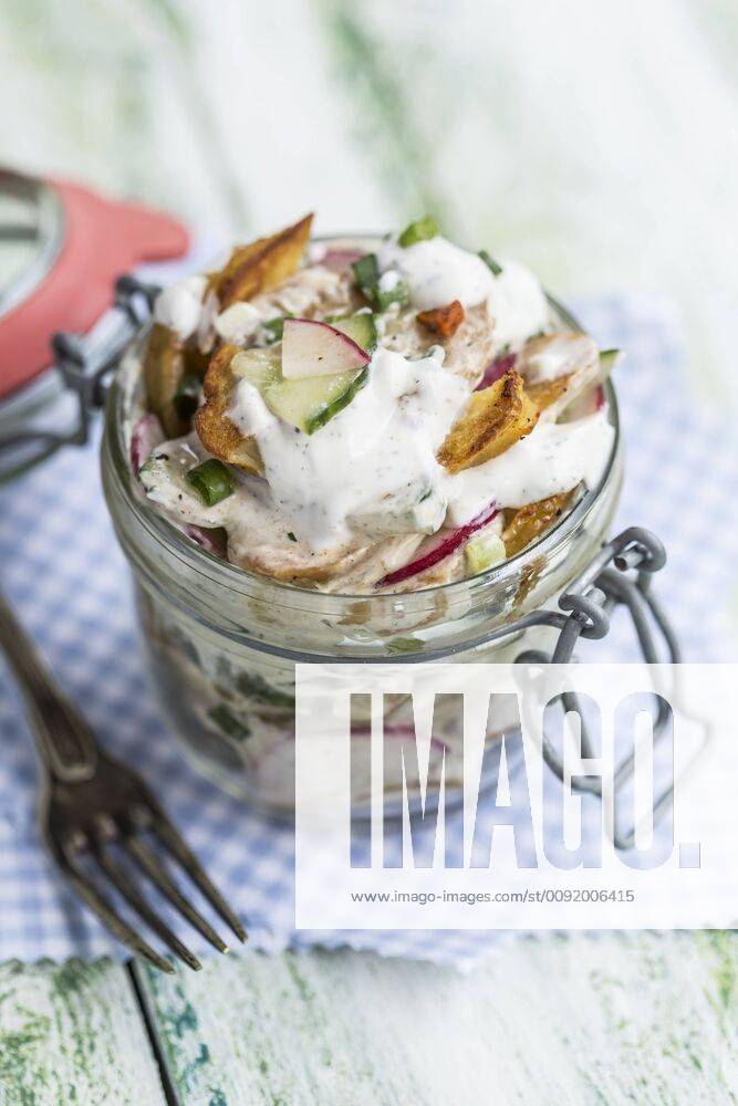 Glass of fried potato salad with cucumber, red radish, spring onions and mayonnaise yoghurt dressing STBF00315