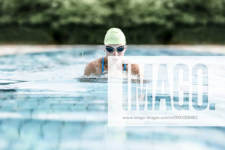 Young woman swimming in swimming pool, breast-stroke swimming model released Symbolfoto STBF00342