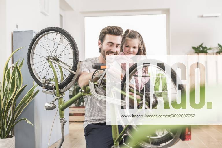 Young man and little girl repairing bicycle together model released Symbolfoto property released UUF17363