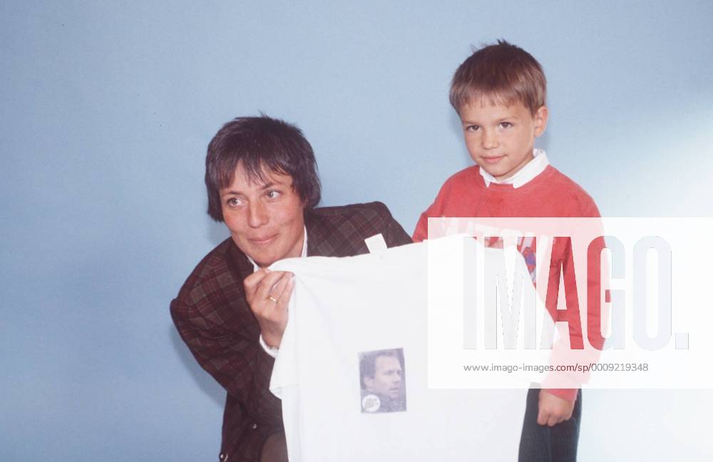 Rosi Mittermaier mit Sohn Felix Neureuther 06 88 rag Frau Wintersport Ski Skifahren T-Shirt hochhaltend halb quer Kind