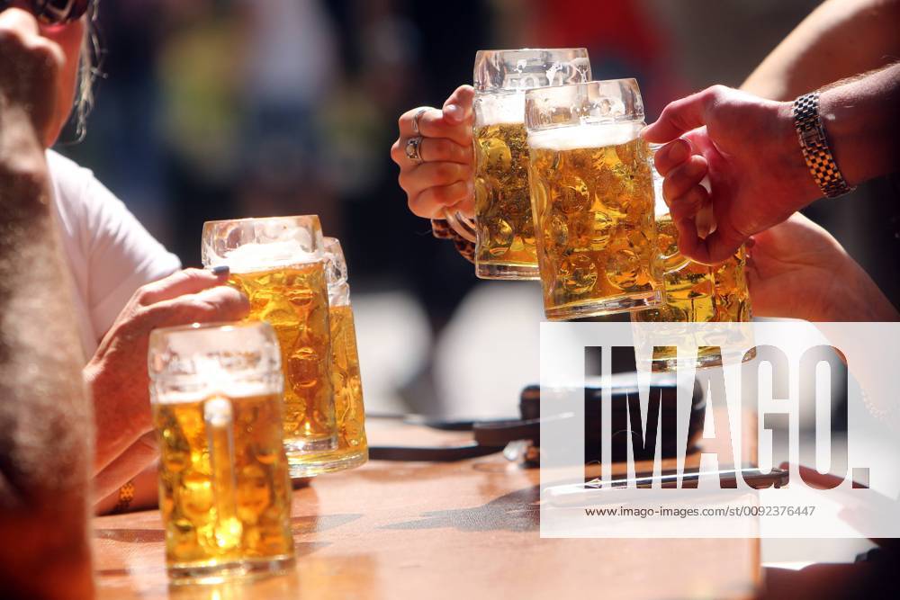 Joint frosting with beer mugs in the beer garden at Viktualienmarkt in Munich, Bavaria, Germany