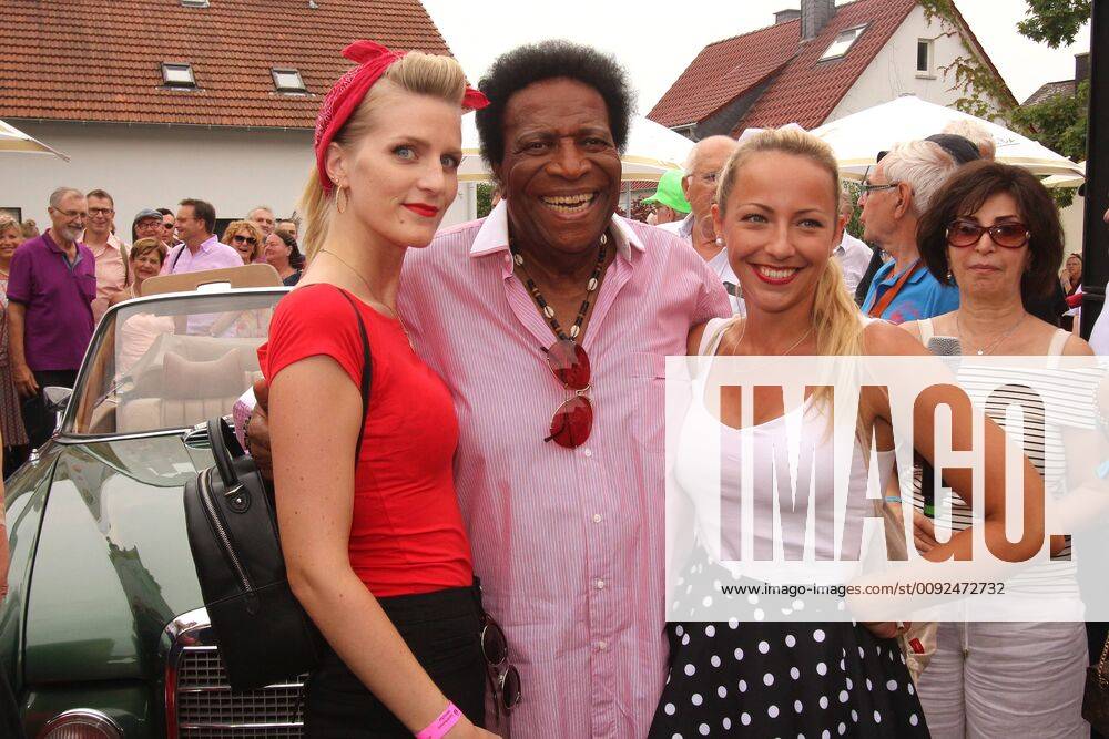 Traditional festival Golden Oldies in Wettenberg near Giessen, Hesse, Germany singer Roberto Blanco in a good mood with two young ladies in arms in front of a Mercedes Oldtimer