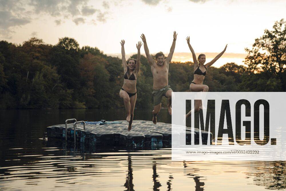 Friends having fun at the lake, jumping from bathing platform model released Symbolfoto property released GUSF02368