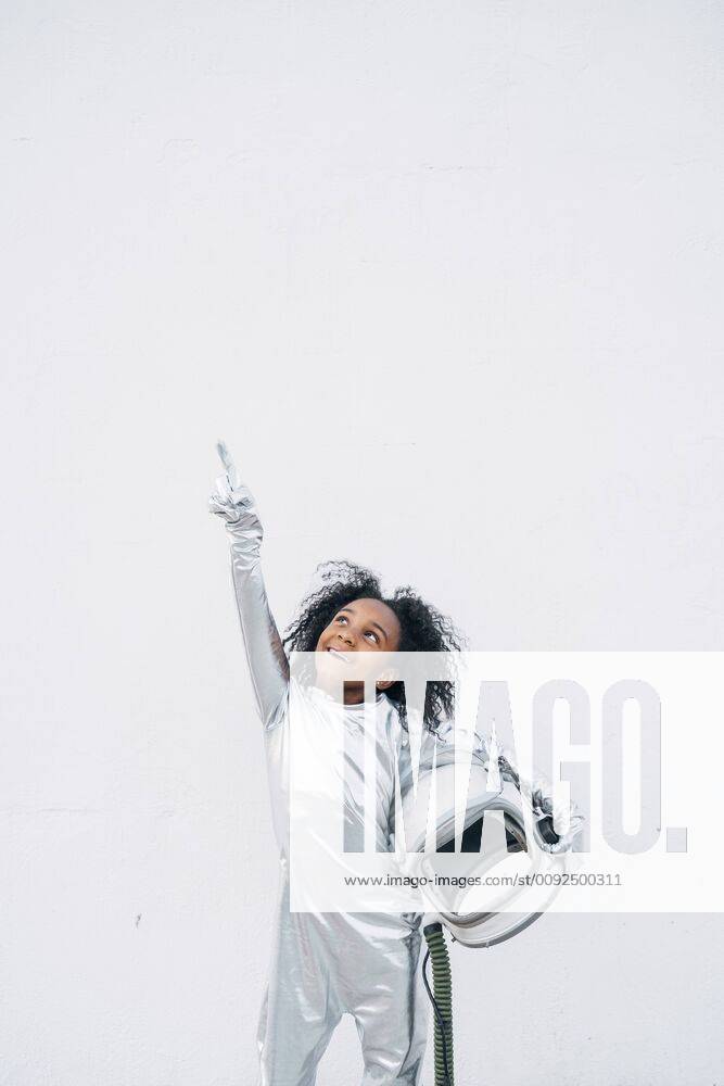 Portrait of smiling little girl wearing space suit in front of white background looking up model released Symbolfoto JCMF00066