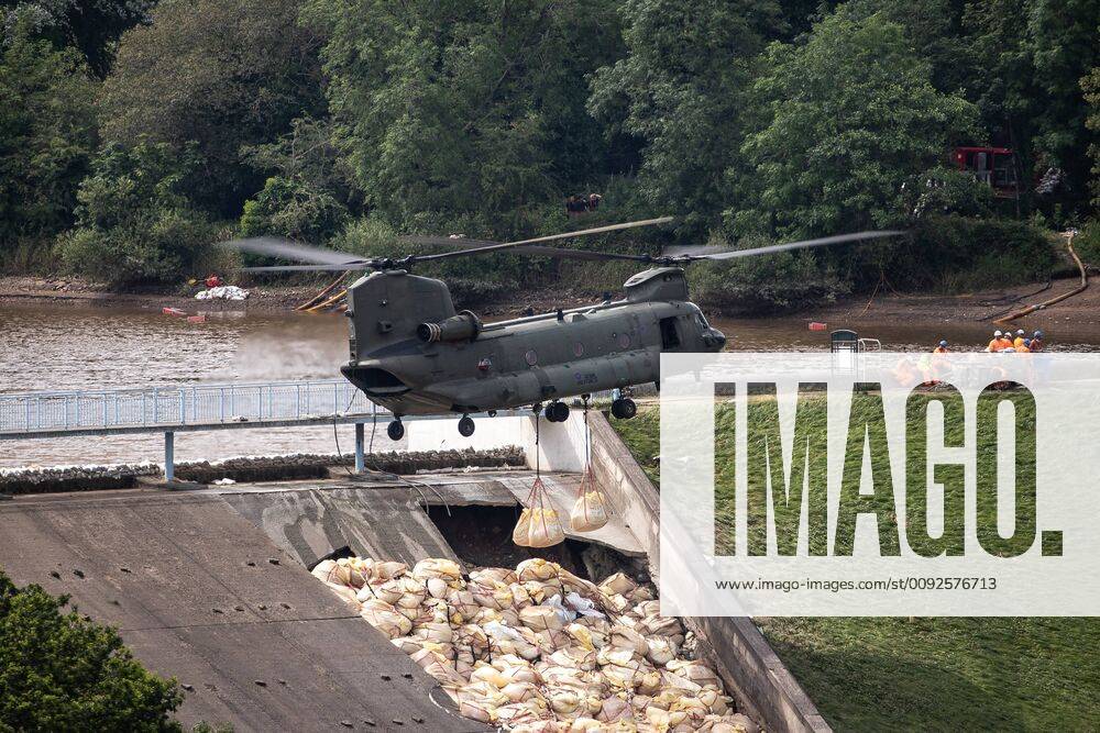 Whaley Bridge, UK. An RAF Chinook helicopter flies in low and drops large sacks of aggregate in to the hole in the slipway . The town of Whaley Bridge in Derbyshire remains evacuated after heavy rain caused damage to a slipway on the Toddbrook Reservoir , threatening homes and businesses with flooding. Whaley Bridge UK - ZUMAl94_ 20190803_zaf_l94_123