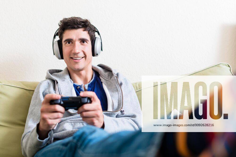 Happy young man playing a video game on console at home