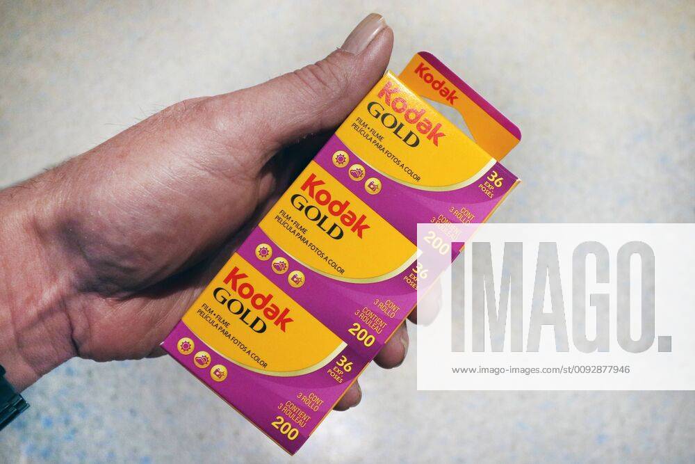 Colour negative films versus digital photography Analog small-format films by Kodak in the hands of a man