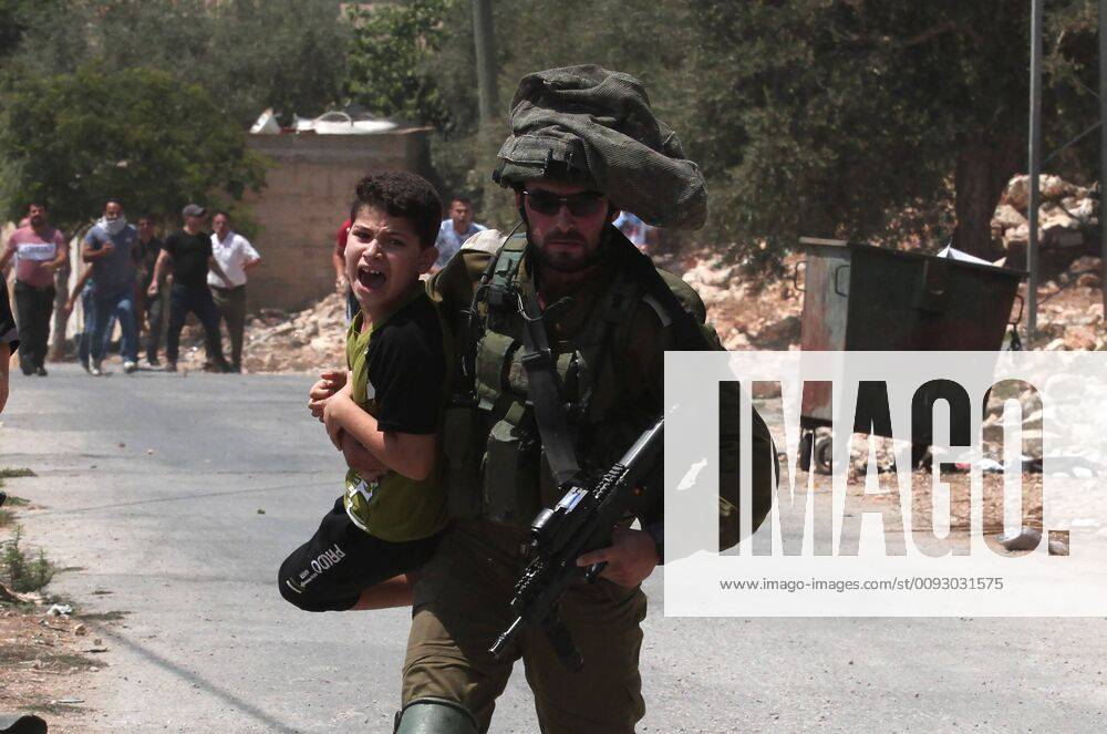 (190823) -- NABLUS, Aug. 23, 2019 (Xinhua) -- An Israeli soldier detains a Palestinian child during clashes, after a protest against the expanding of Jewish settlements in Kufr Qadoom village near the West Bank city of Nablus, Aug. 23, 2019. (Photo by Nidal Eshtayeh Xinhua) MIDEAST-NABLUS-CLASHES