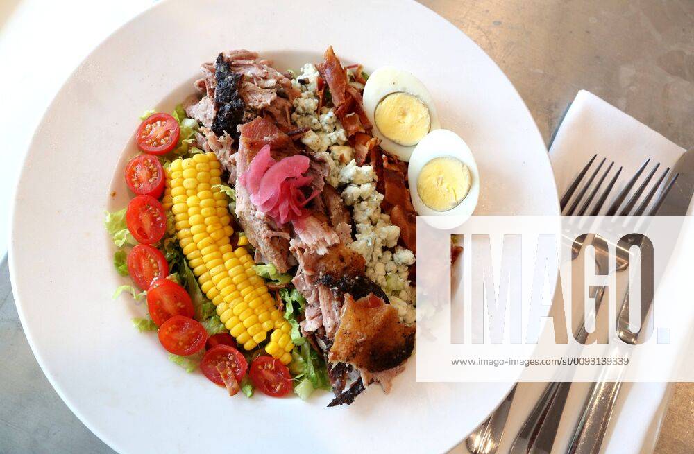 A Dewey Cobb Salad made with Barbecue Pork Shoulder, corn, applewood bacon, tomatoes, hard boiled egg, blue cheese, and poblano buttermilk vinaigrette dressing is offered at the Dewey Beach Restaurant in Pass-a-Grille. St. Pete Beach USA - ZUMAs70_ 20190828_zan_s70_038