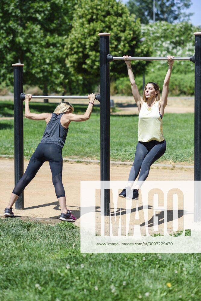 Mature woman exercising with her daughter in a park model released Symbolfoto JSMF01154